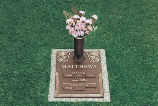 A grave with a vase of flowers on top of it