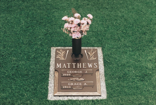 A gravestone for george matthews with a vase of flowers on it.