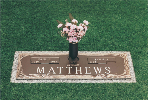 A grave of matthews with a vase of flowers on it