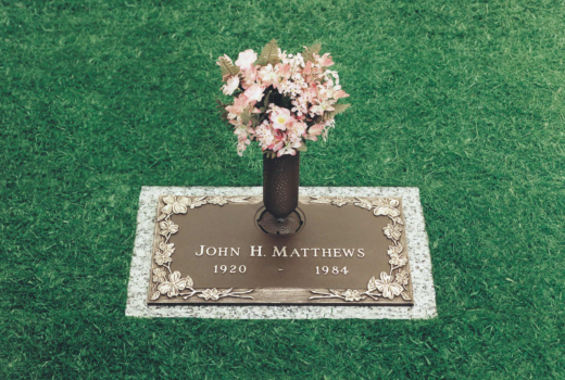 A gravestone for john h matthews with a vase of flowers on it