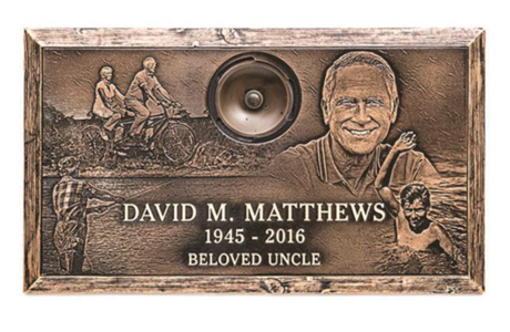A bronze plaque with a picture of a man and a speaker on it.