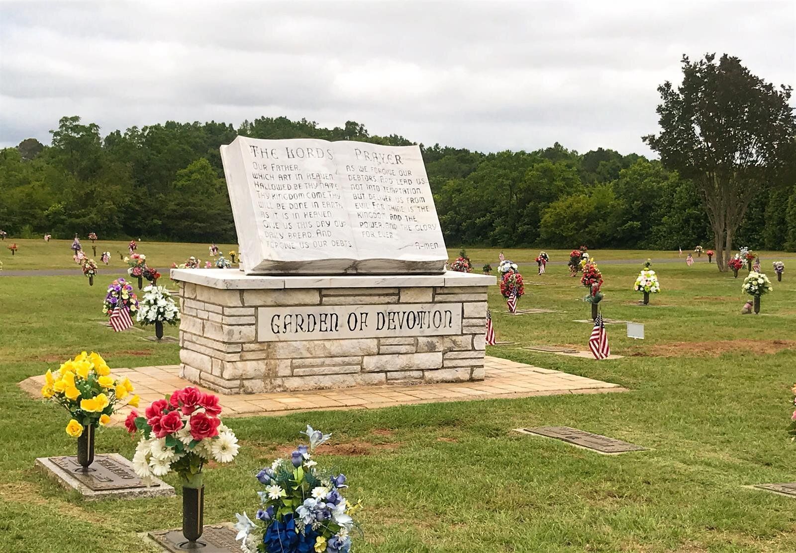A cemetery with flowers and a memorial in the middle