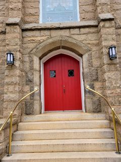 Hands exchanging a $100 bill. One hand is light-skinned, the other is darker. Background: blue and white.