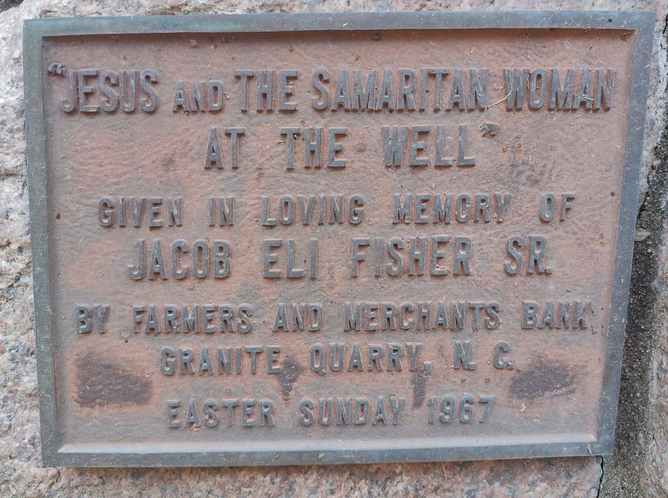 Bronze plaque memorializing Jacob Eli Fisher Sr., mentioning Jesus, the Samaritan woman, a bank, and Easter Sunday 1867.