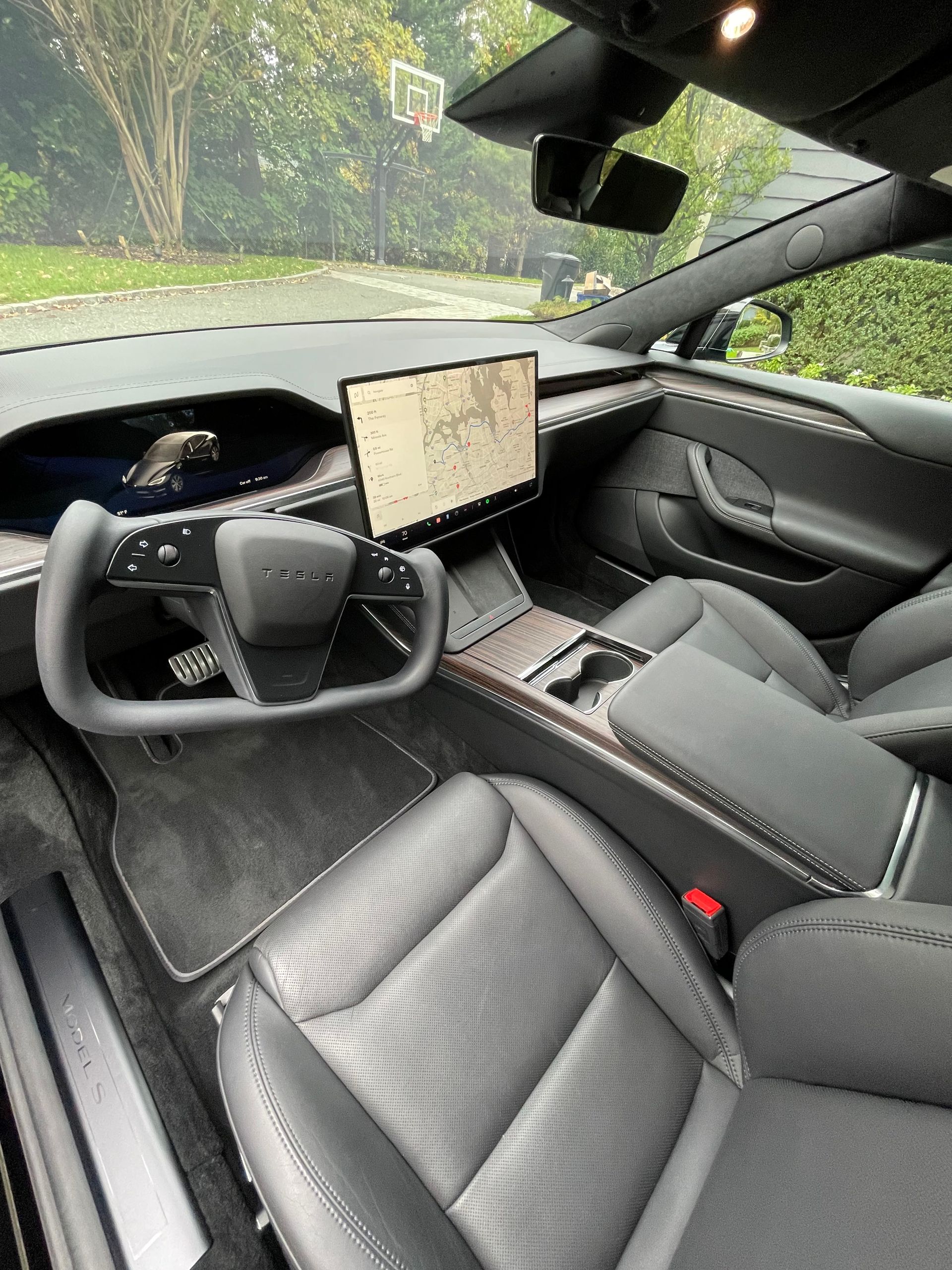 The interior of a tesla model s with a tablet on the dashboard.