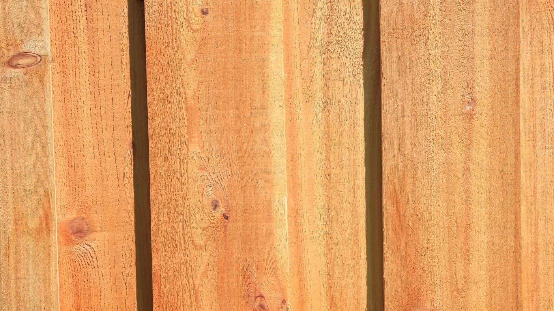 A close up of a wooden fence made of wooden boards.