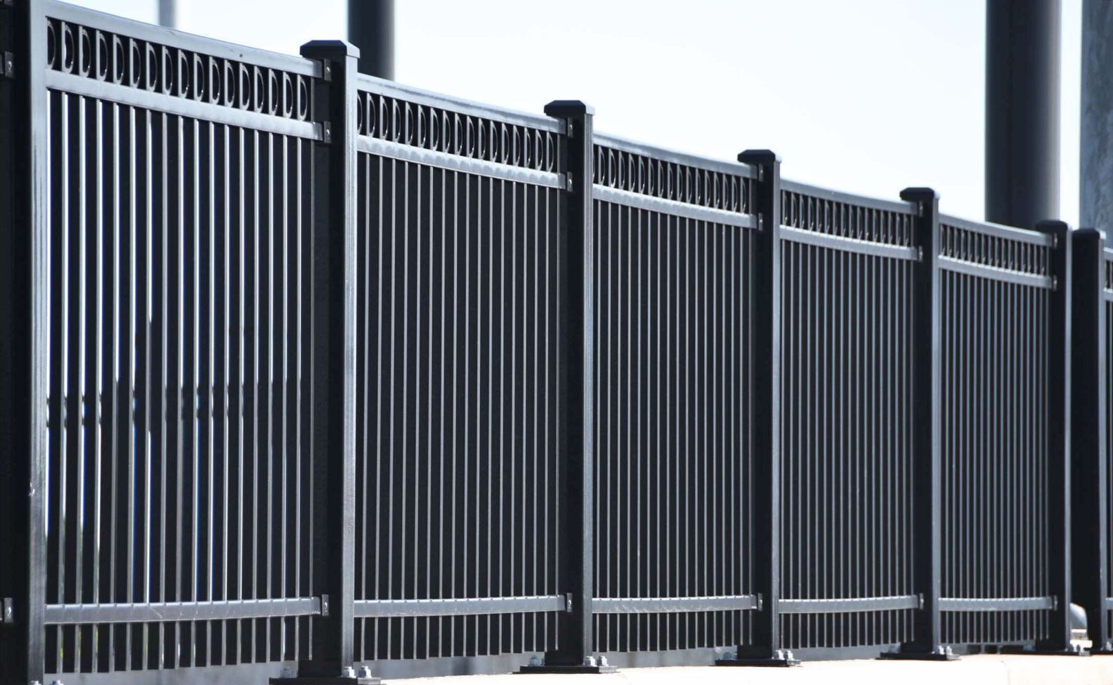 Black metal fence with vertical bars, outdoors.