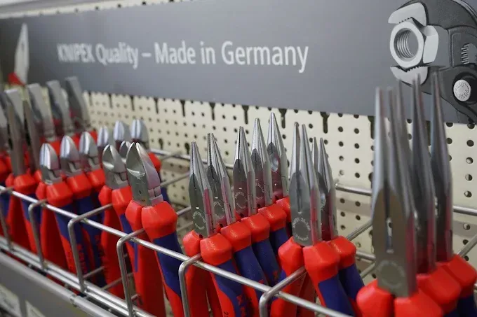Présentoir d'outils Knipex à manches rouges et bleus, avec inscription « Fabriqué en Allemagne ».