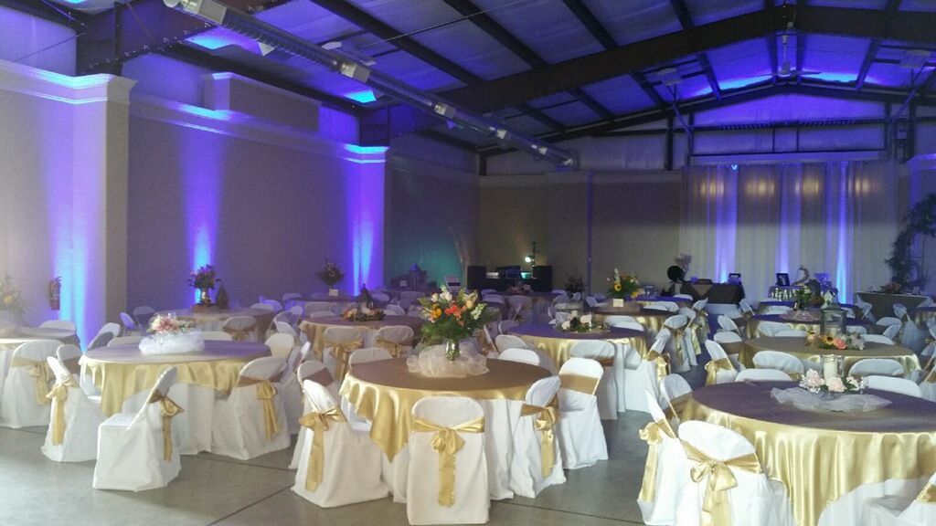 A large room with tables and chairs set up for a wedding reception.