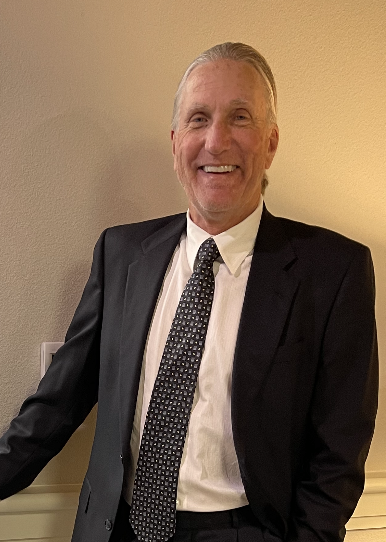 A man in a suit and tie is smiling for the camera.