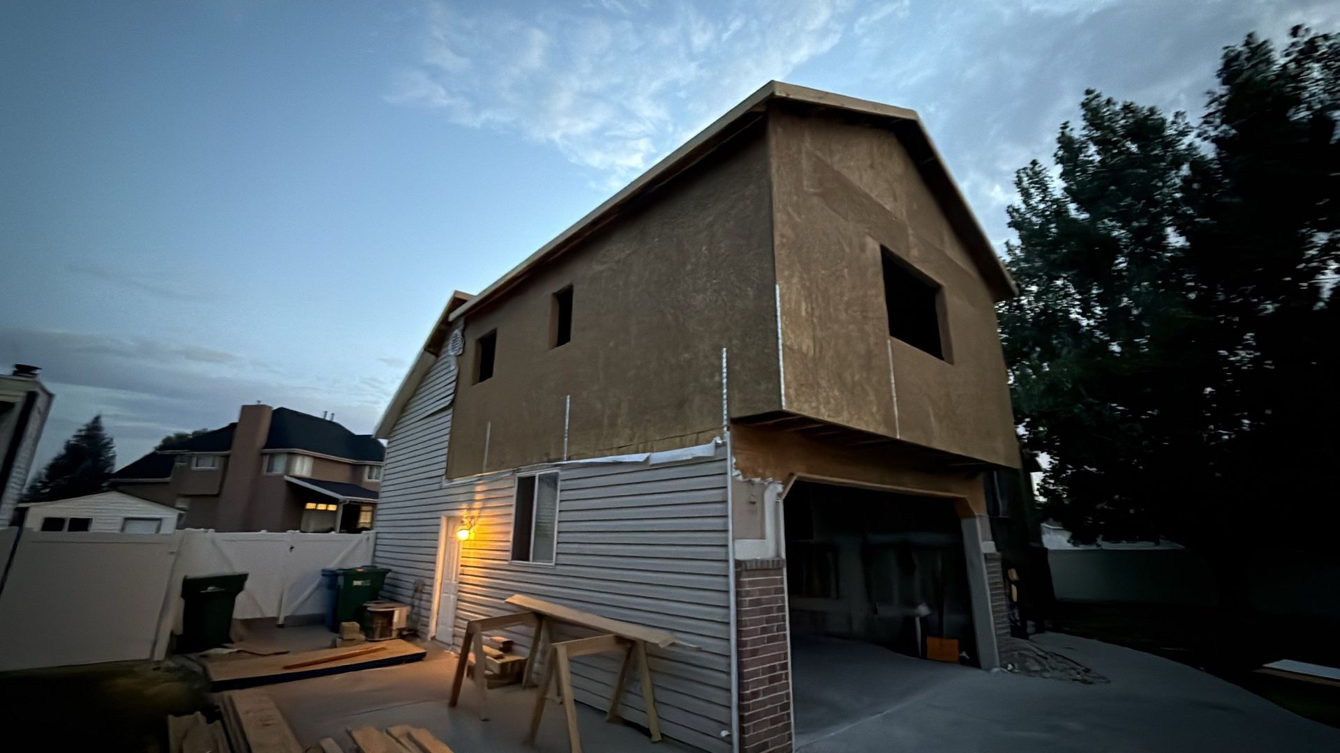 A two-story building under construction; unfinished siding and exposed wood framing.