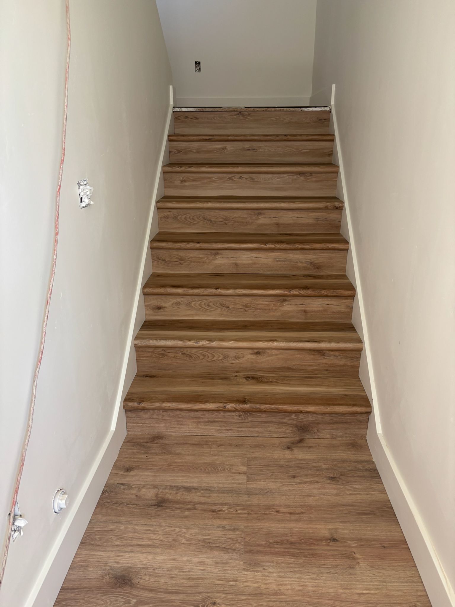 Wooden stairs with white walls and trim.