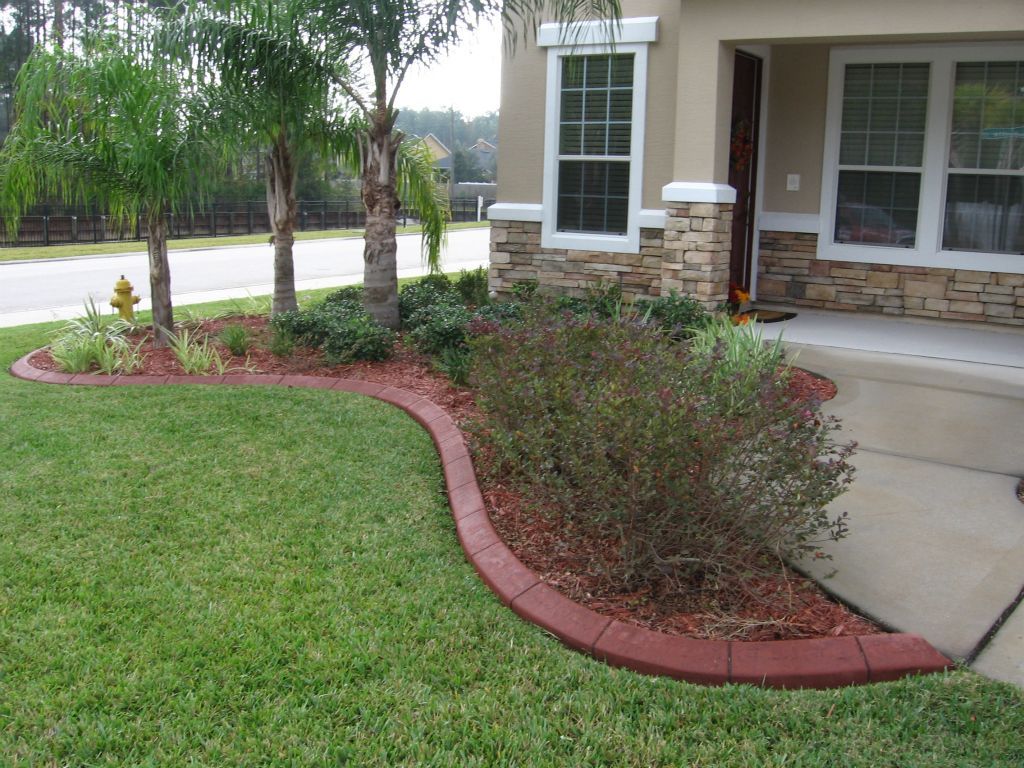 A lawn with a red curb in front of a house