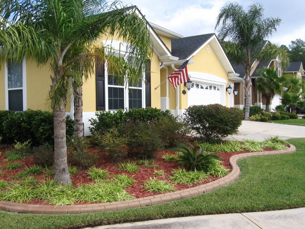 A yellow house with an american flag in front of it