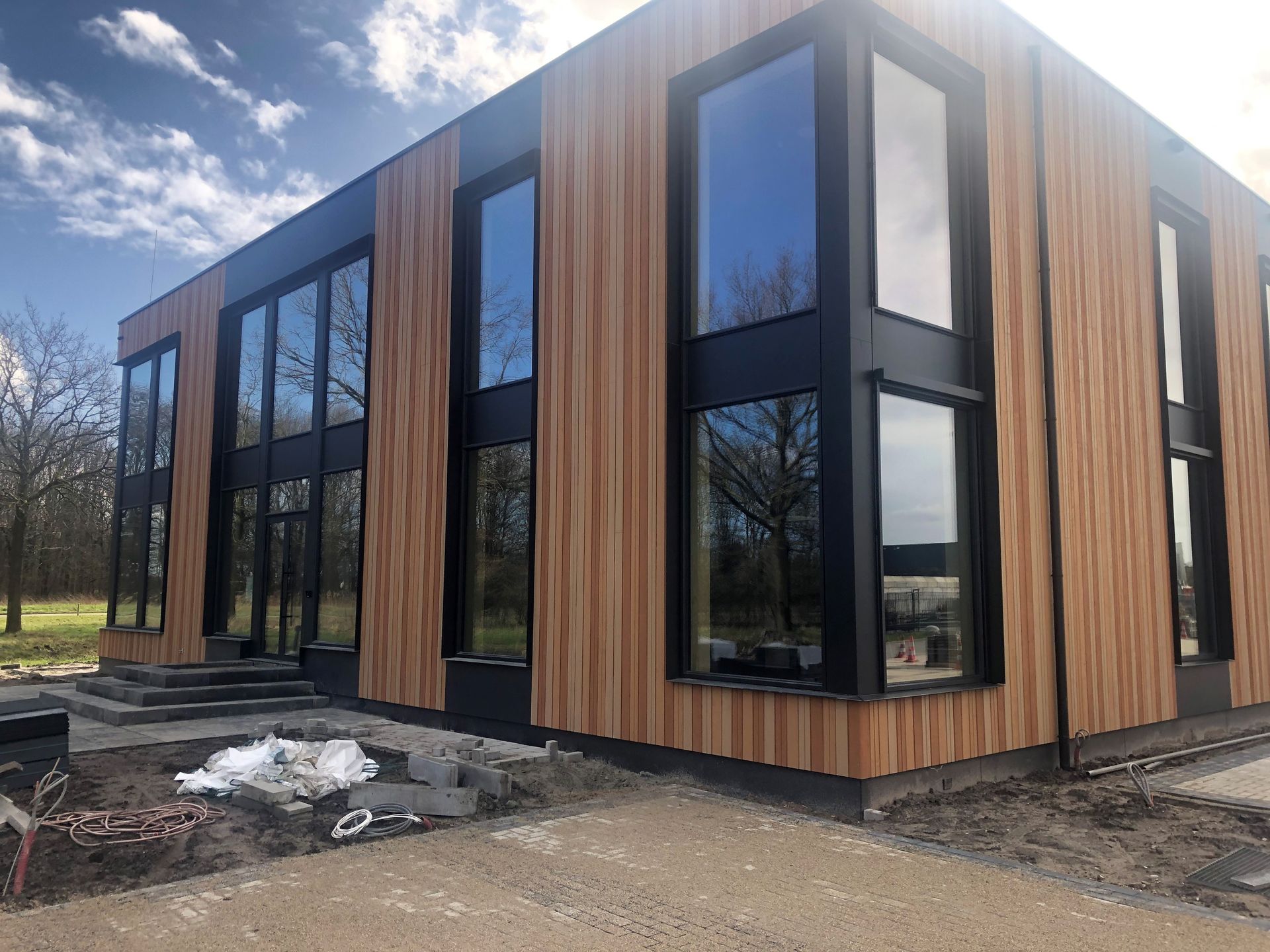 Een groot gebouw met veel ramen en een houten gevel.