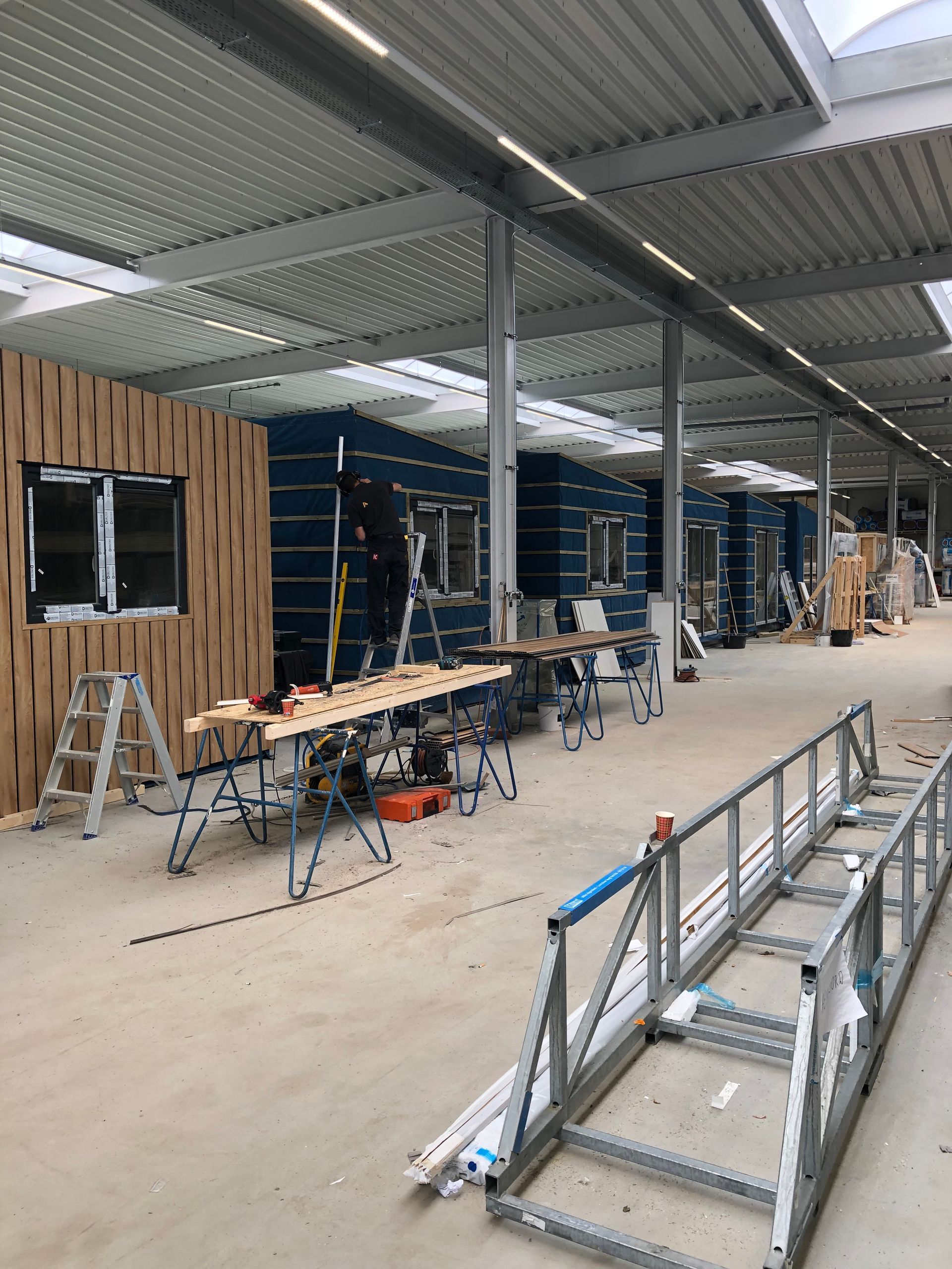 Een groot gebouw in aanbouw met veel ladders en tafels