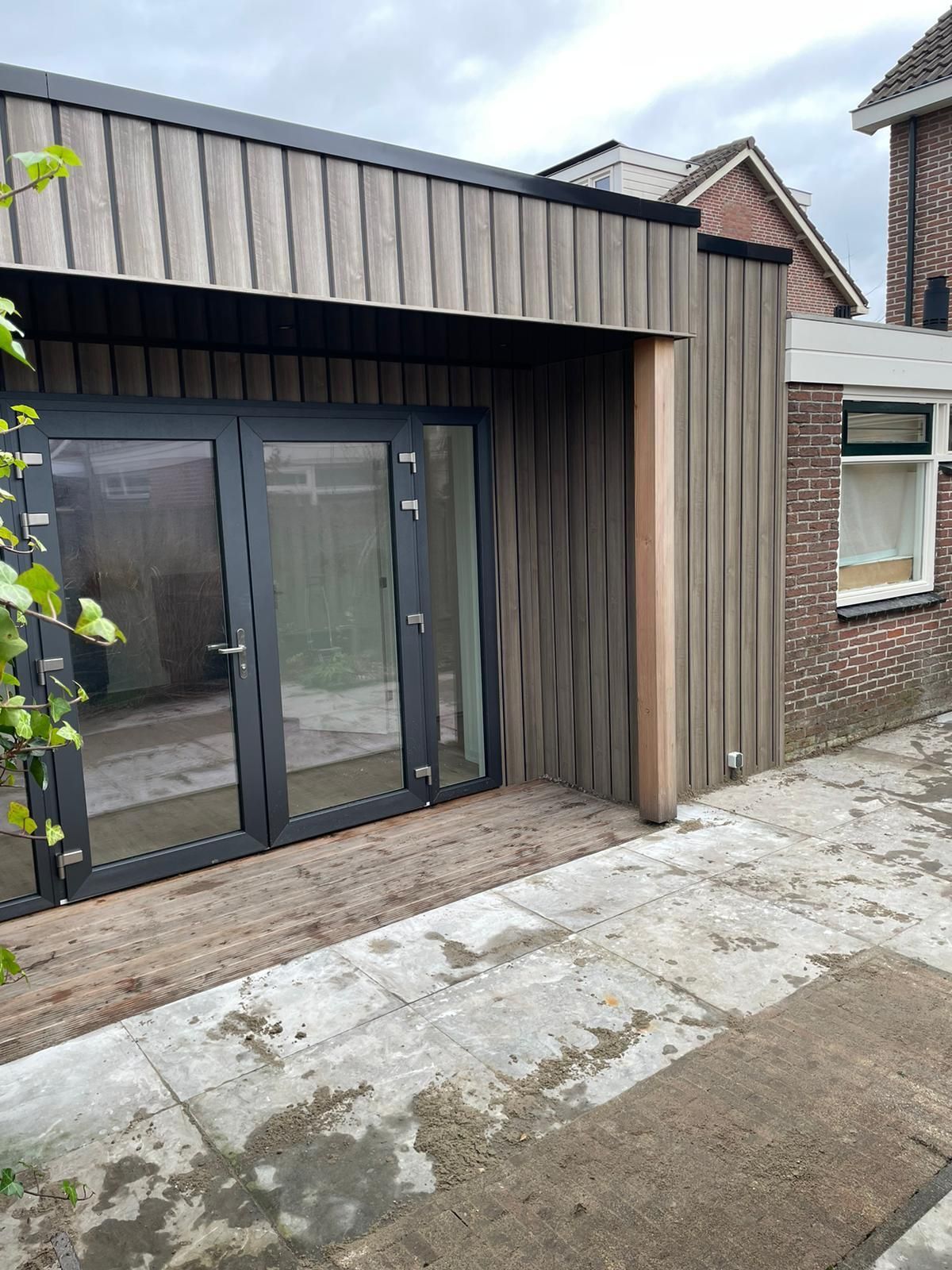 Een bakstenen gebouw met een houten dak en glazen schuifdeuren.