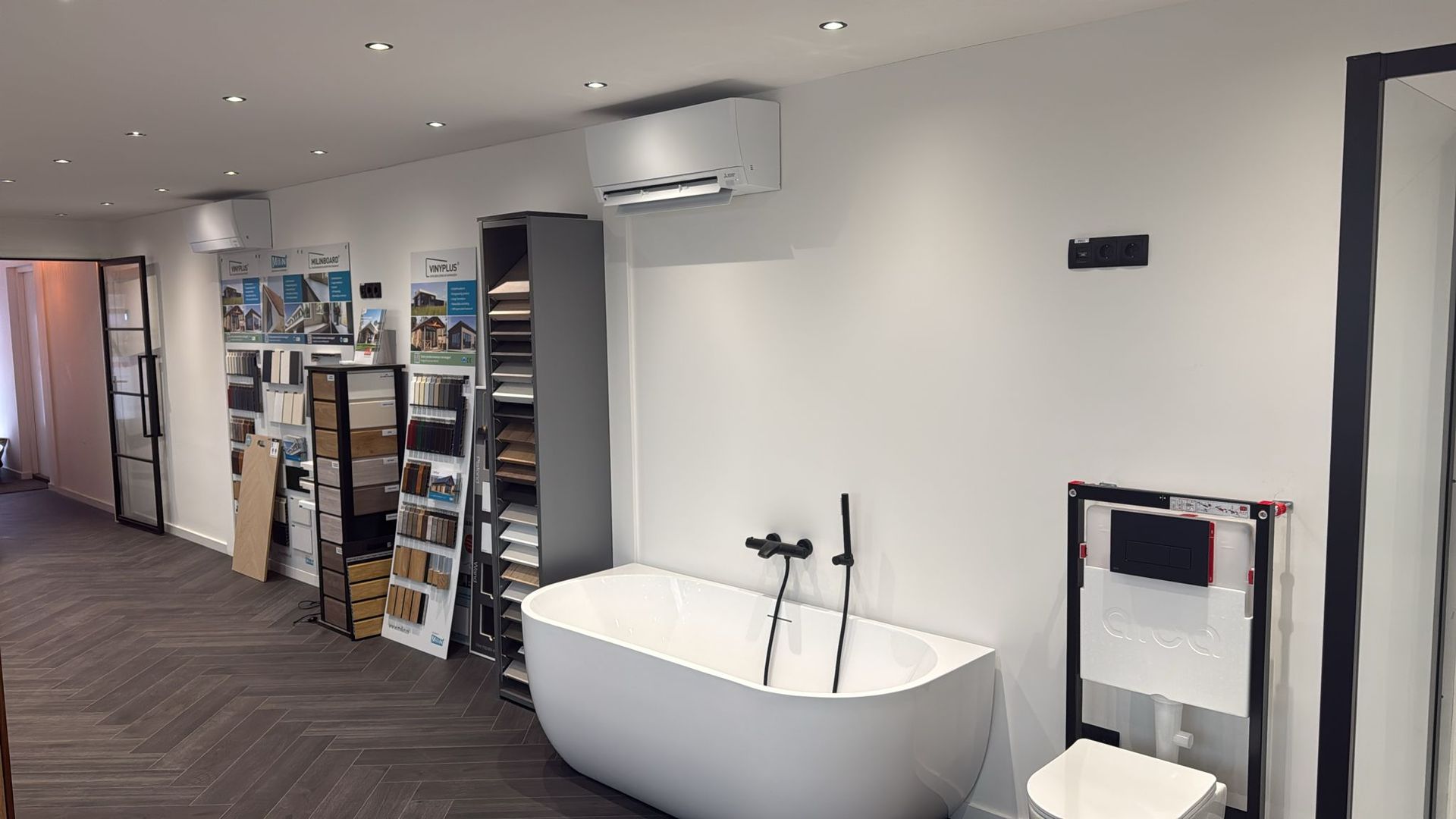 Een badkamer met ligbad, toilet en planken.