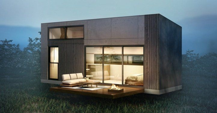 Een klein huisje met veel ramen en een vuurplaats ervoor.