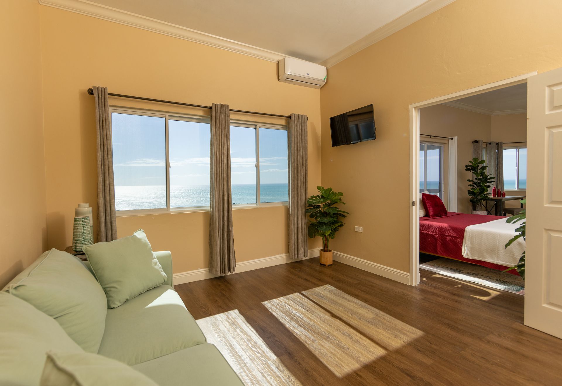 Living room with ocean view, sofa, and door to bedroom.