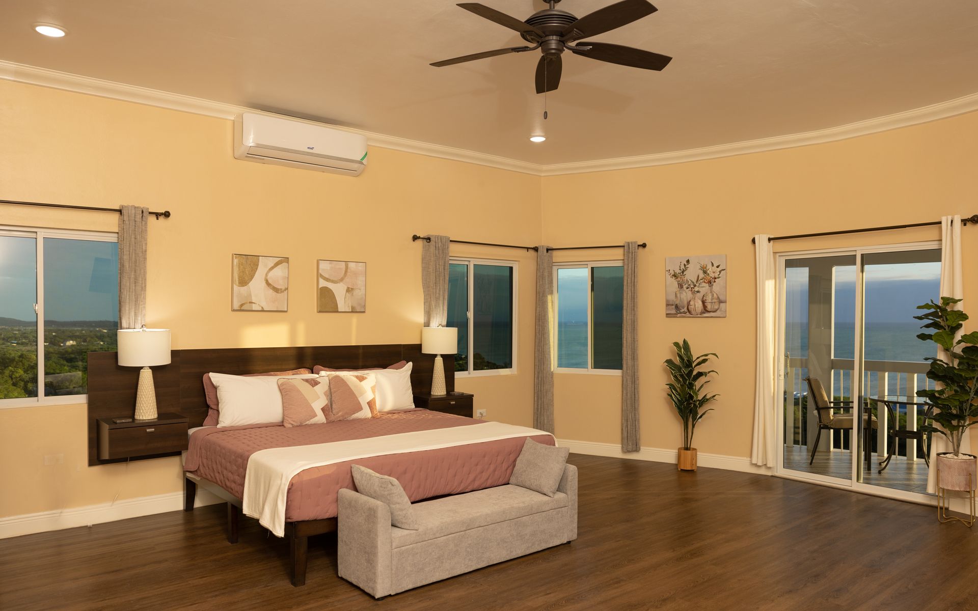 Spacious bedroom with a king-size bed, sliding doors to a balcony, and ocean view.