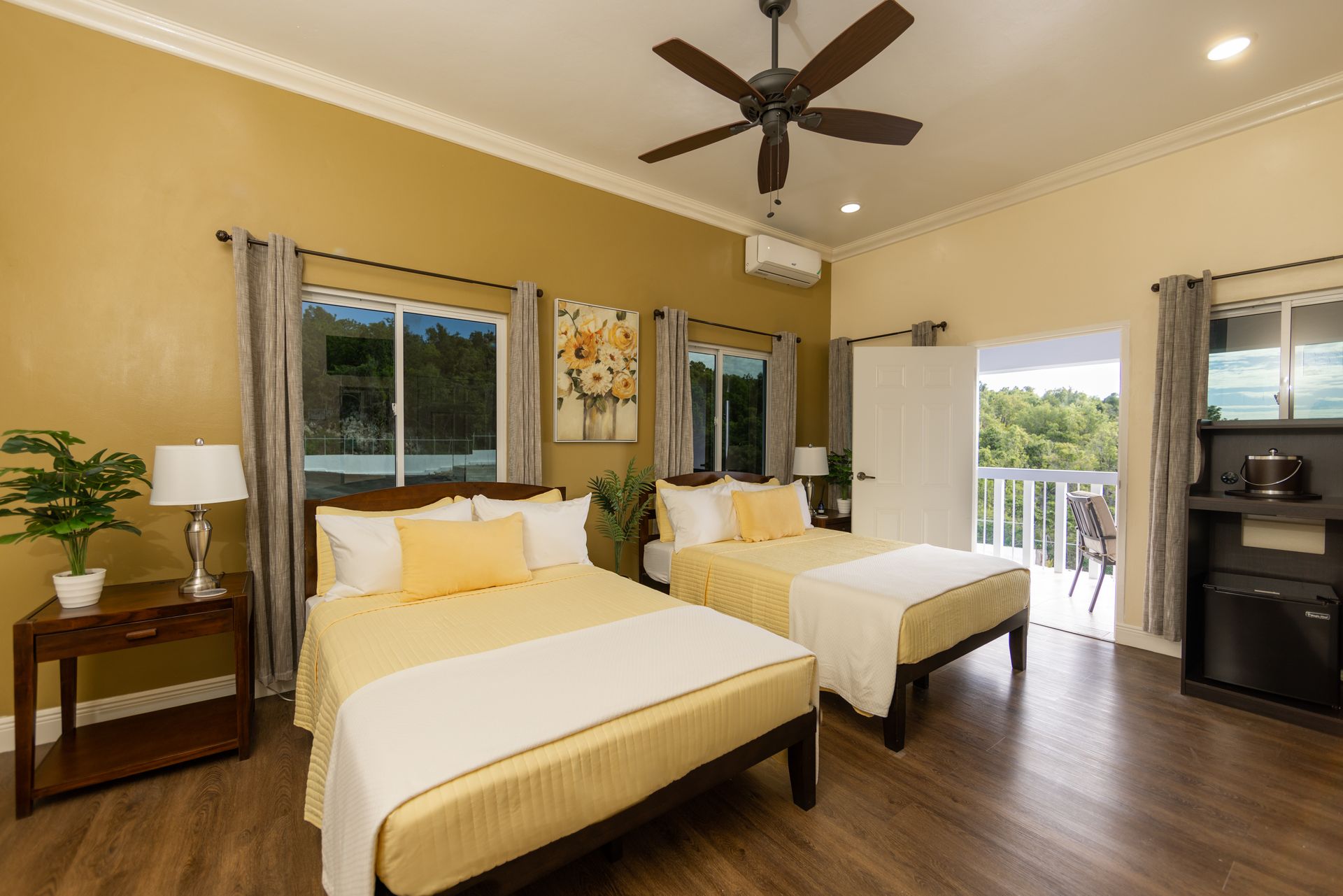 Bedroom with two beds, yellow accents, and access to a balcony.