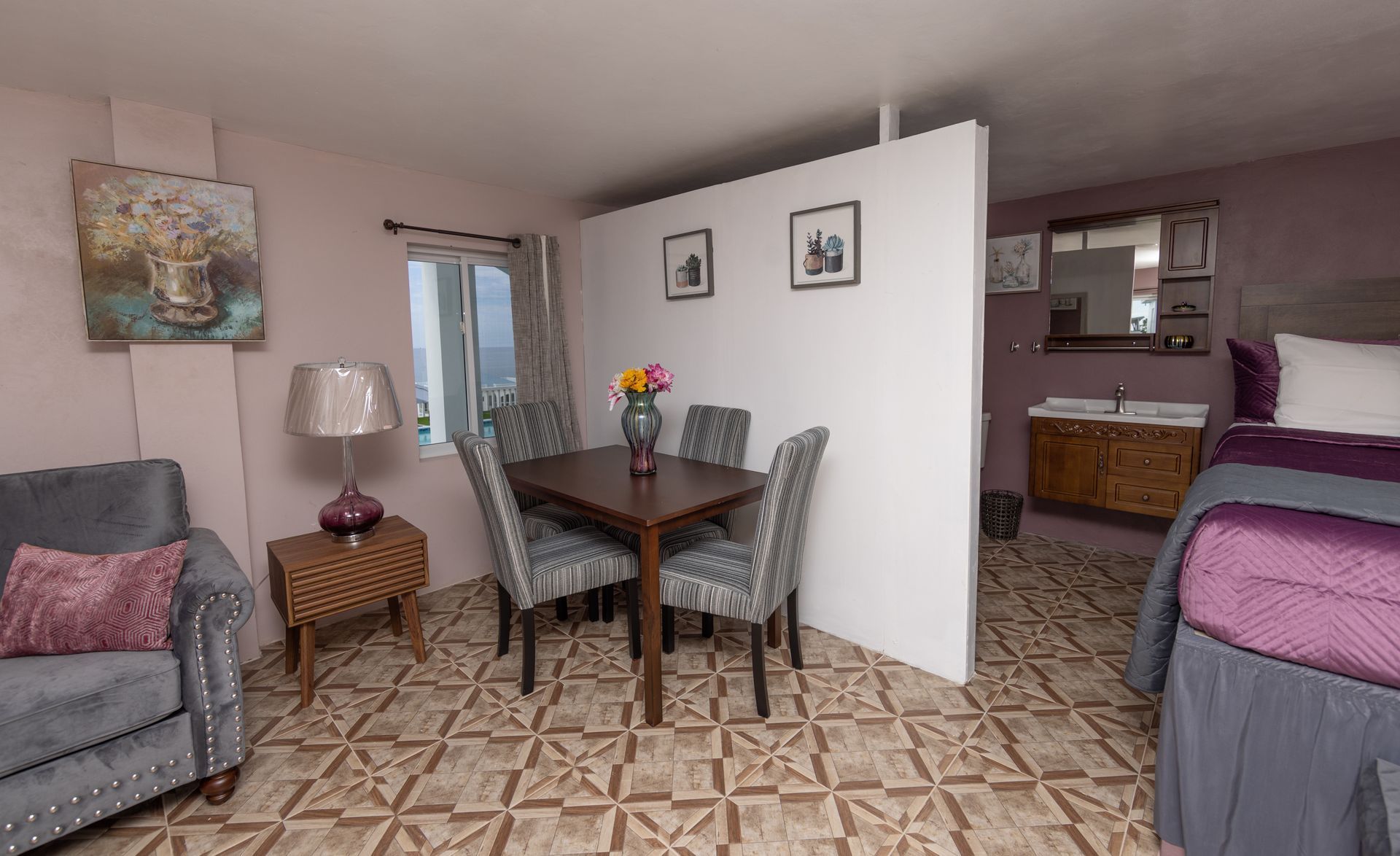 Hotel room with a dining area, a seating area, and a bed.