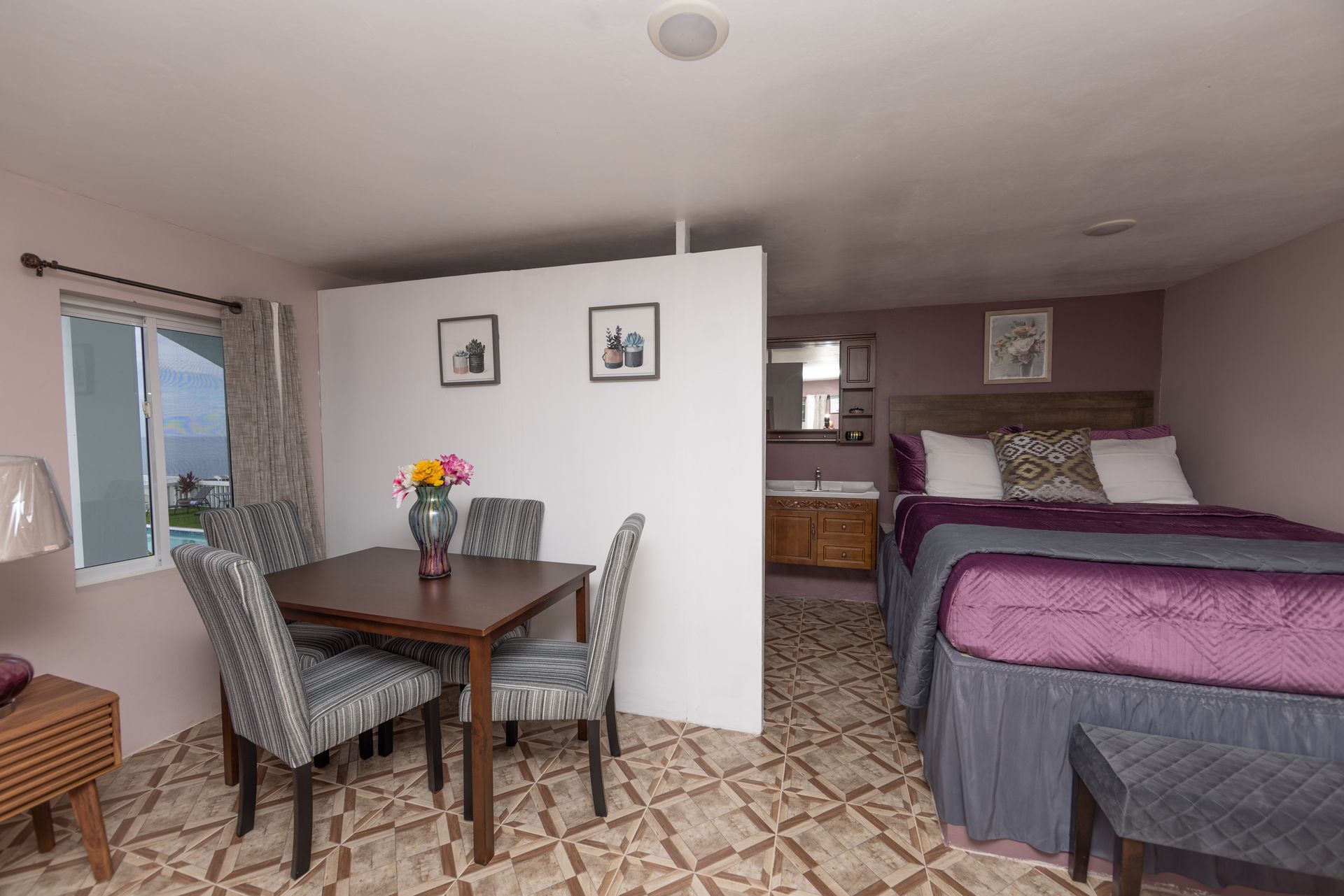 Studio apartment with a dining area, bed, and bathroom.