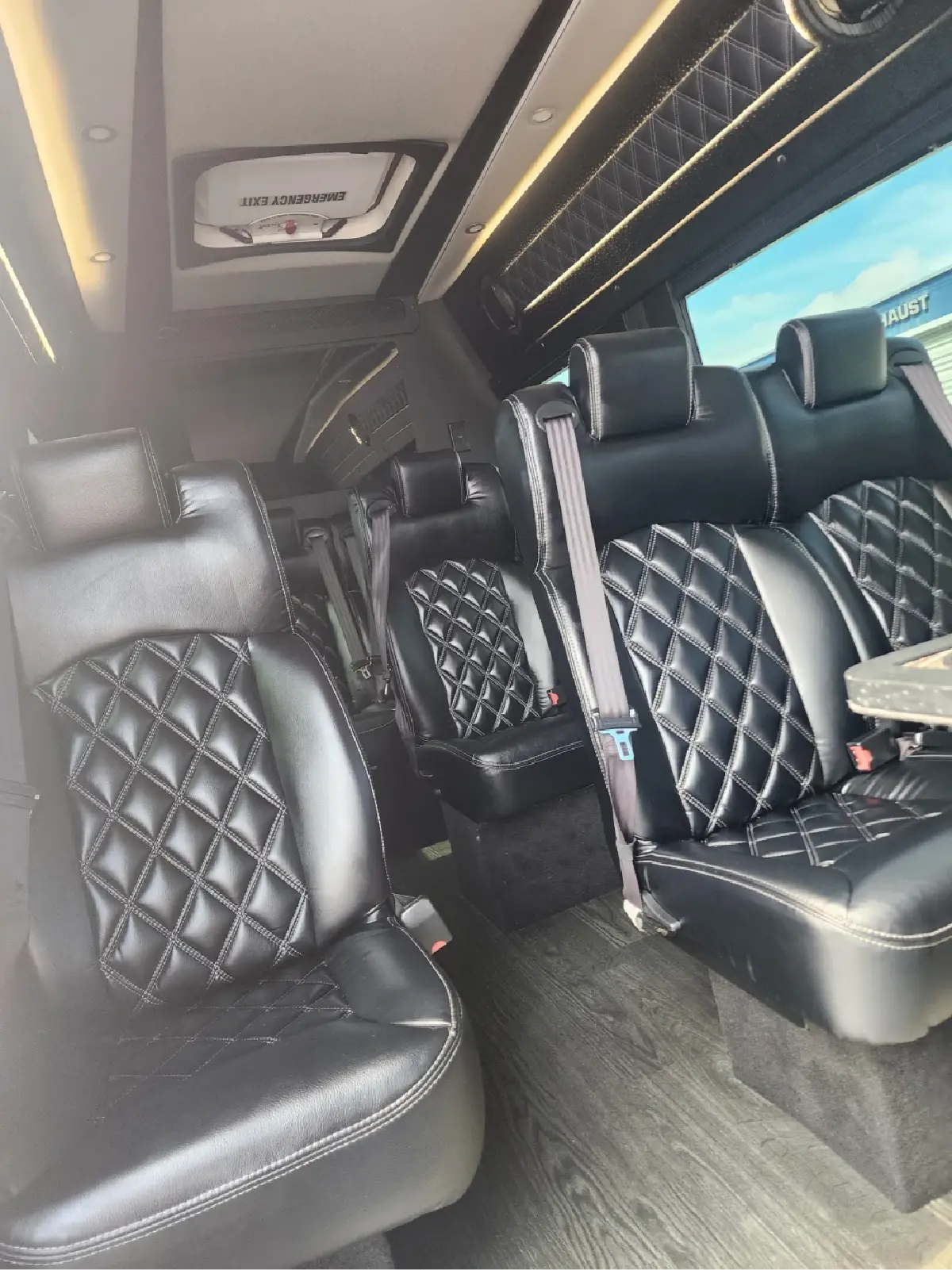 The inside of a van with black seats and a table.