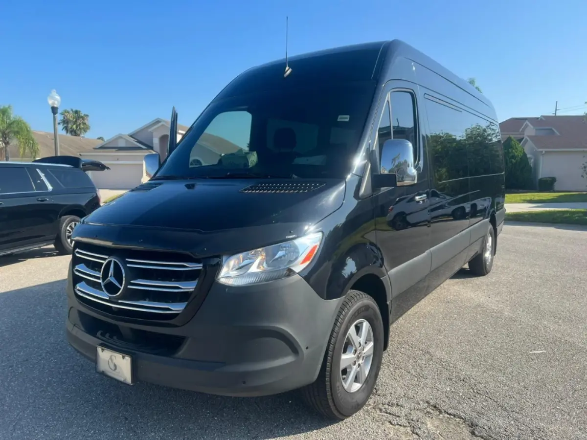 A black mercedes sprinter van is parked in a driveway.