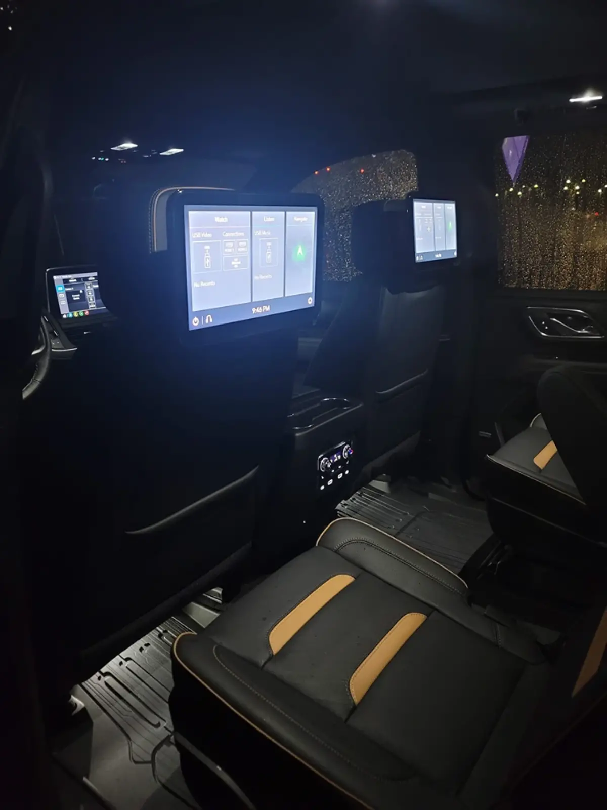 The back seat of a car with two monitors on the headrests