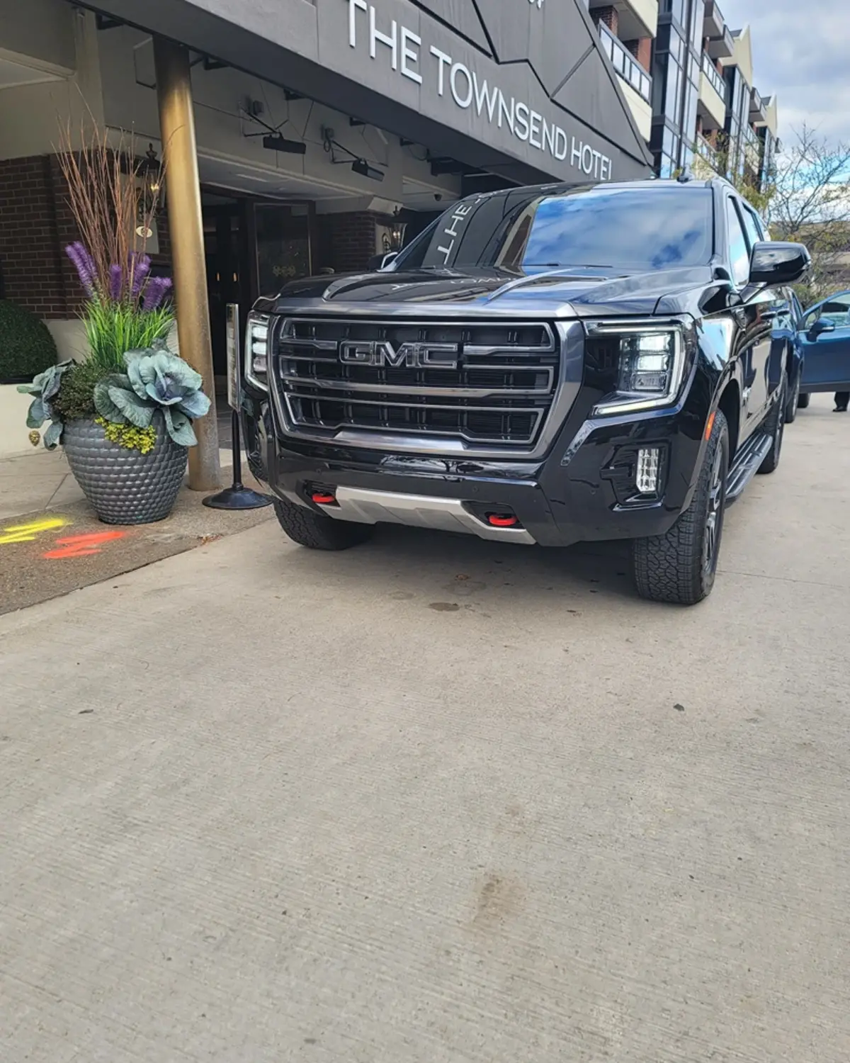 A black gmc truck is parked in front of a building.