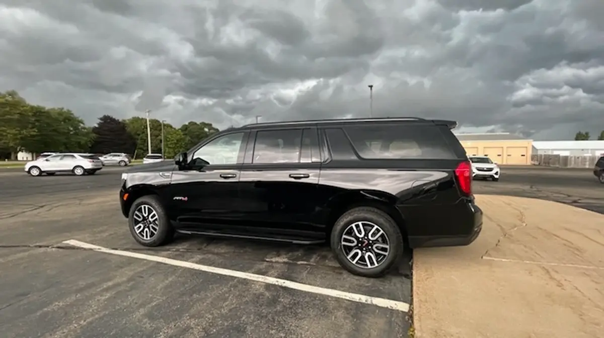 A black suv is parked in a parking lot on a cloudy day.