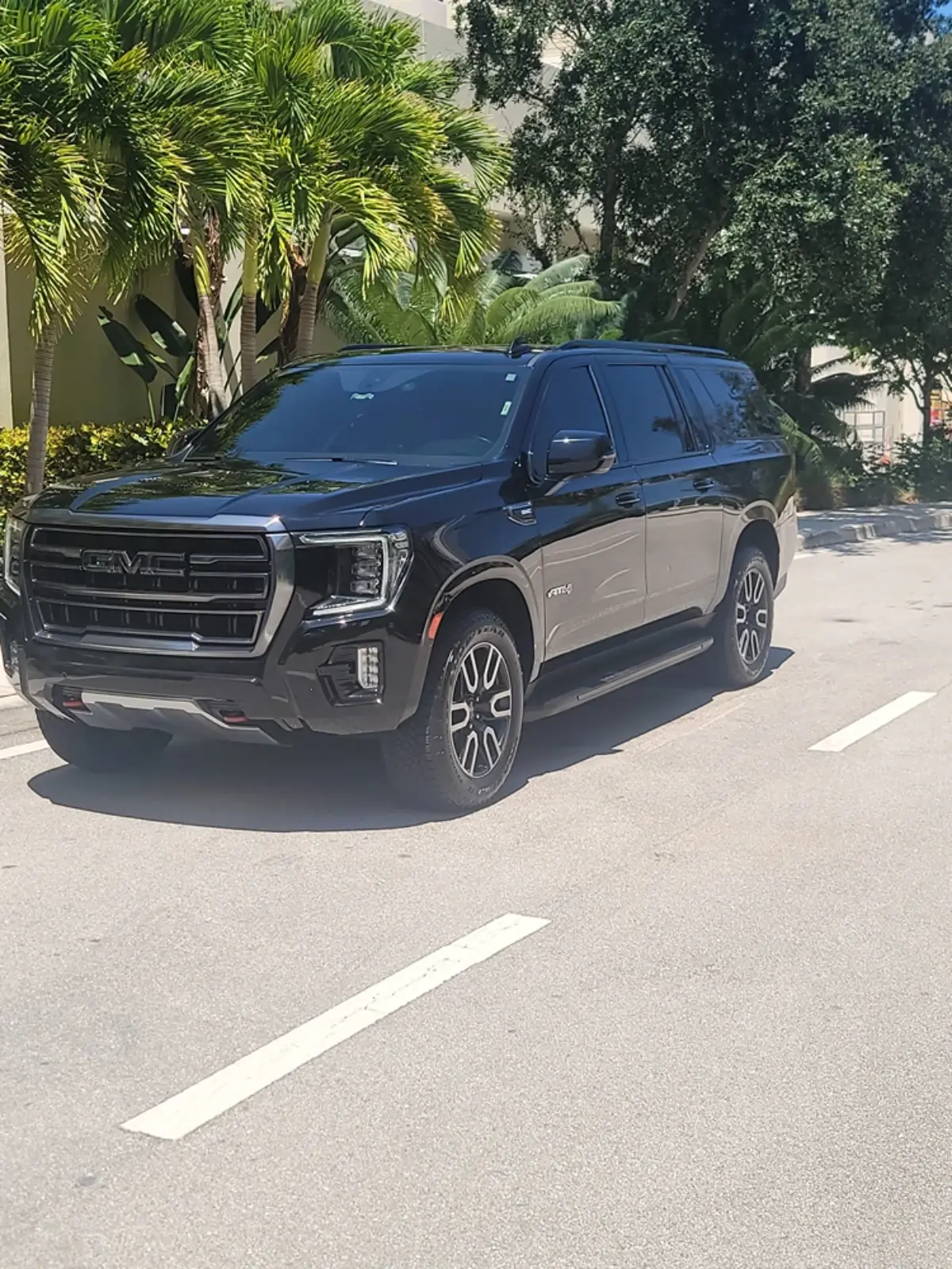 A black suv is parked on the side of the road.