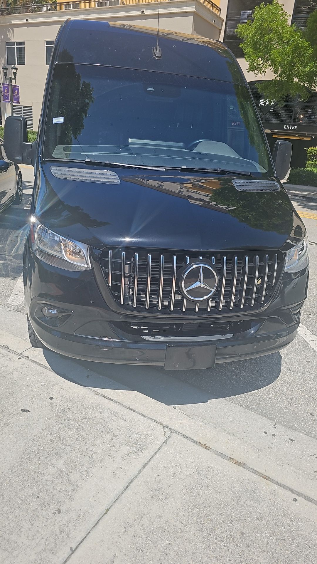 A black van is parked on the side of the road.