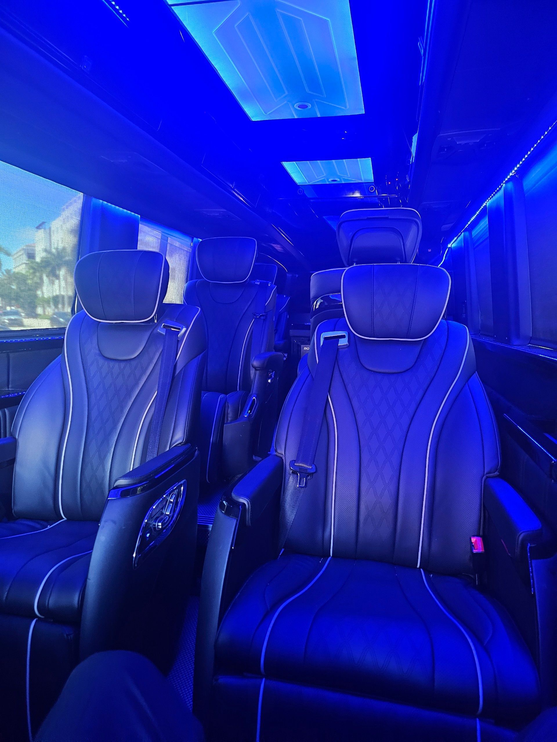 The inside of a van with blue lights on the ceiling.