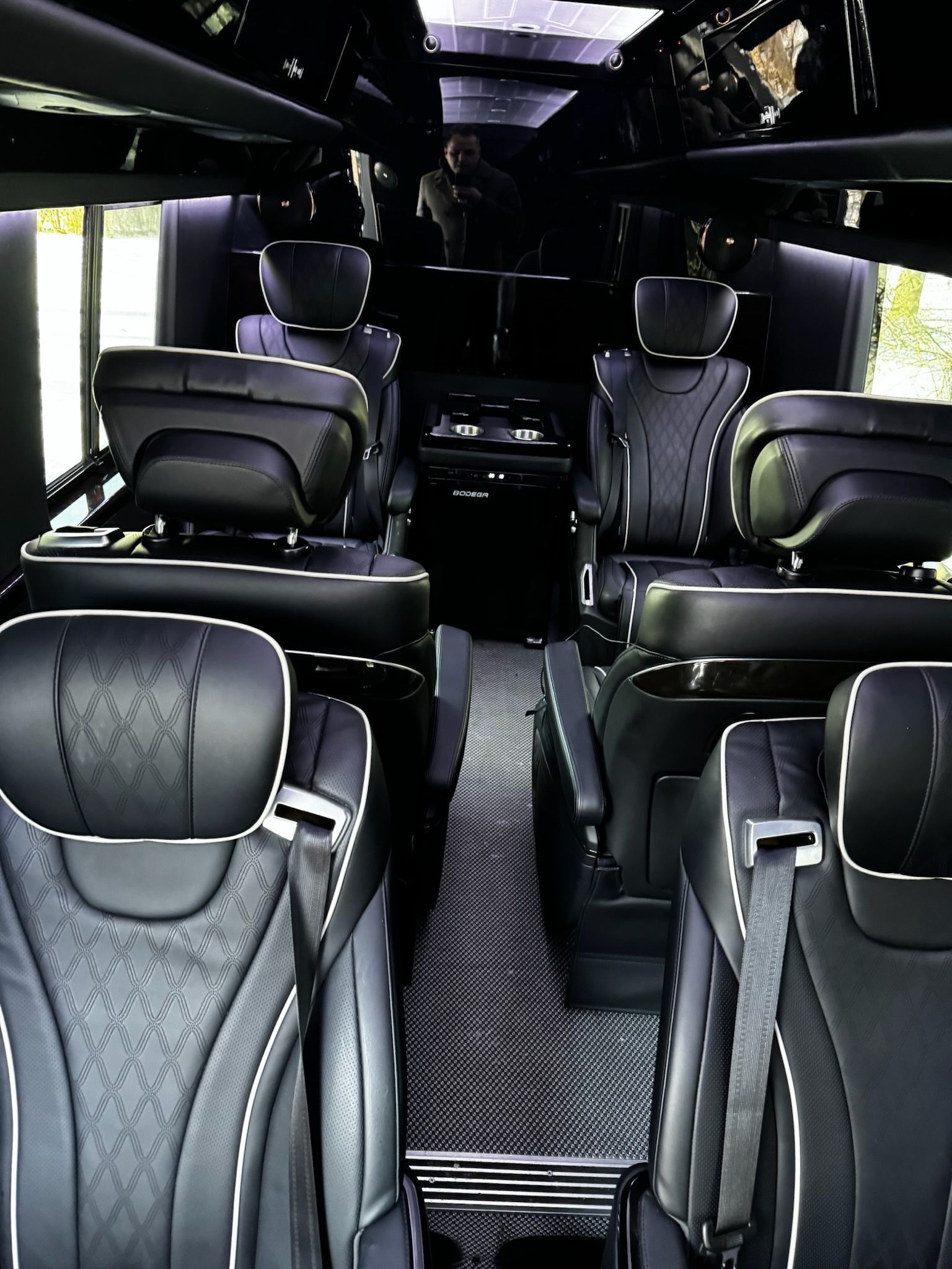 The inside of a van with a lot of seats and a table.