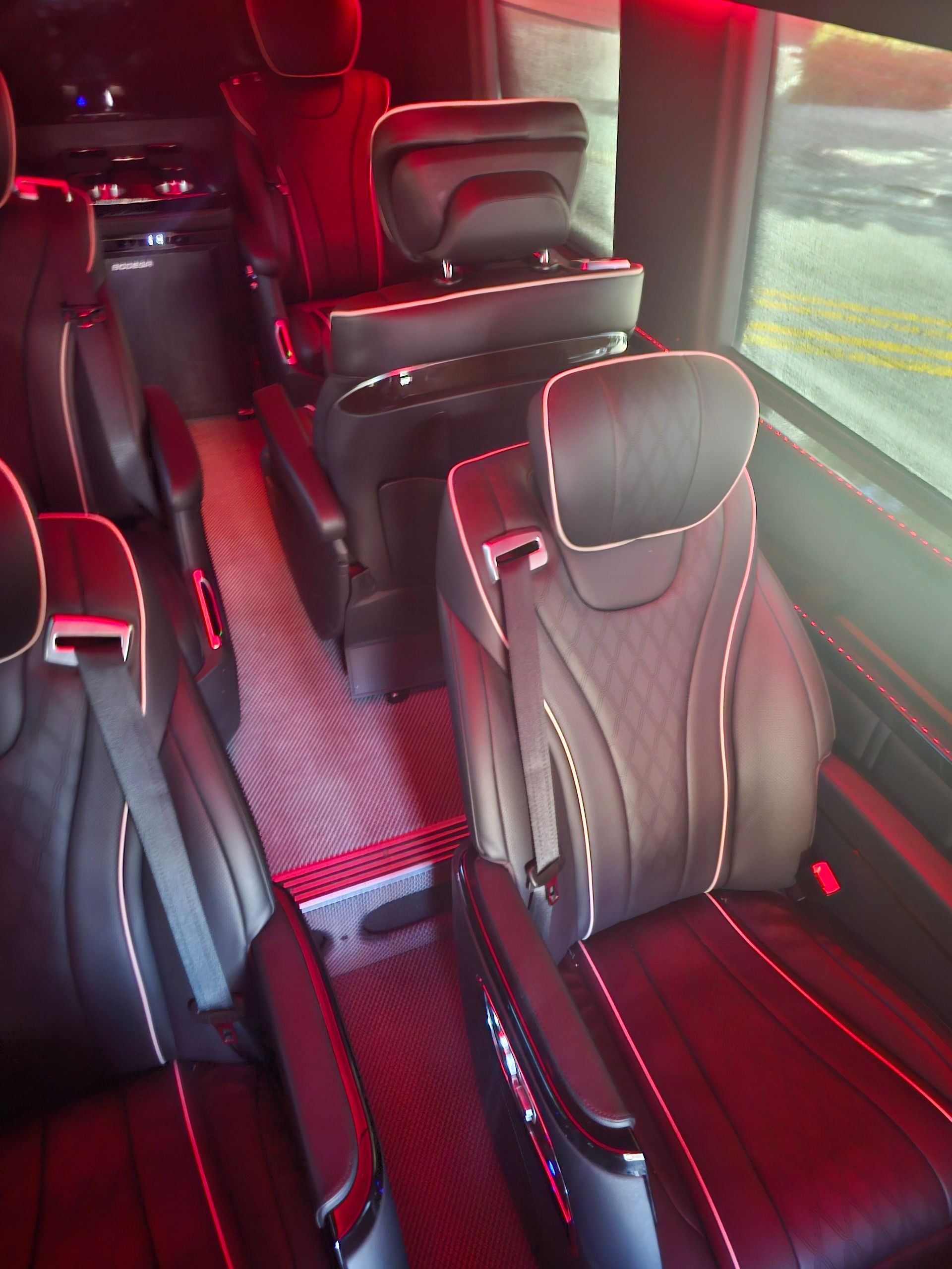 The inside of a van with a lot of seats and red lights.