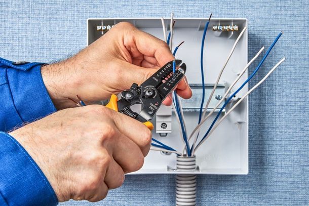 An image of an electrician installing electrical junction boxes.