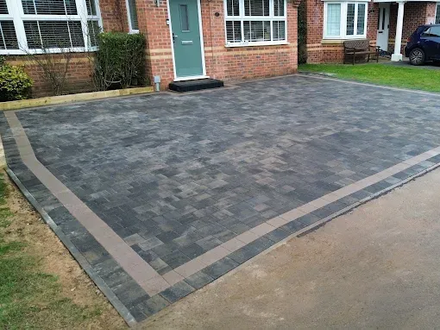 White resin paths split into two around a raised flowerbed, bordered by light-coloured stone walls.