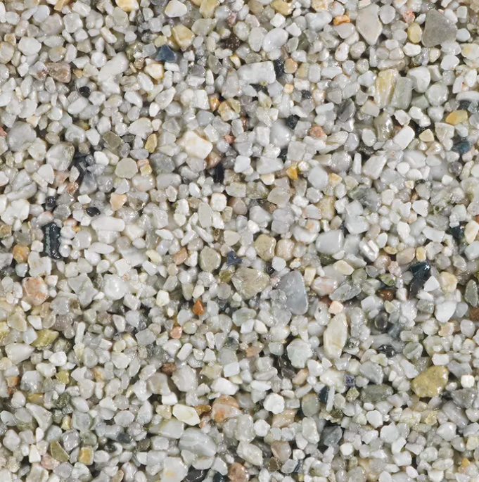 Close-up of a speckled aggregate surface with white, gray, and tan stones.
