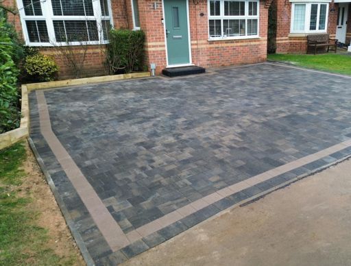 Close-up of dark, wet gravel with various sizes and shades of gray, black, and brown stones.