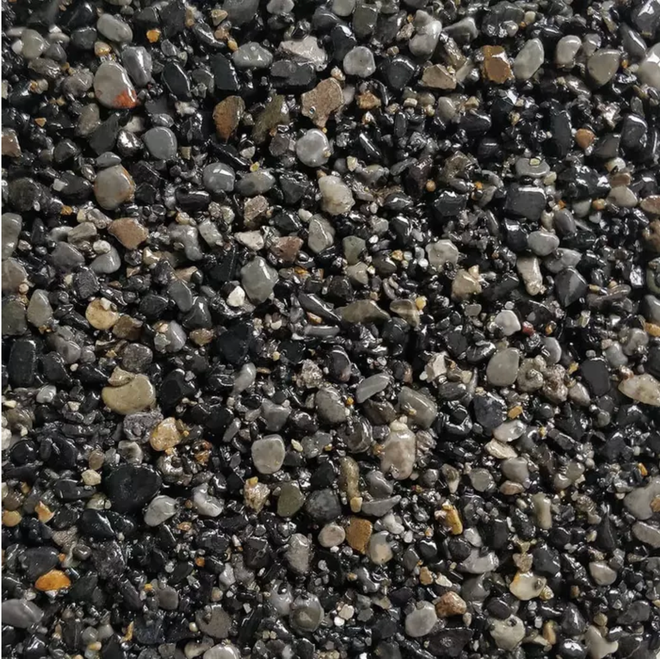 Close-up of dark, wet gravel with various sizes and shades of gray, black, and brown stones.