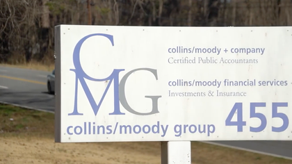 A man and a woman are standing next to each other in a park.