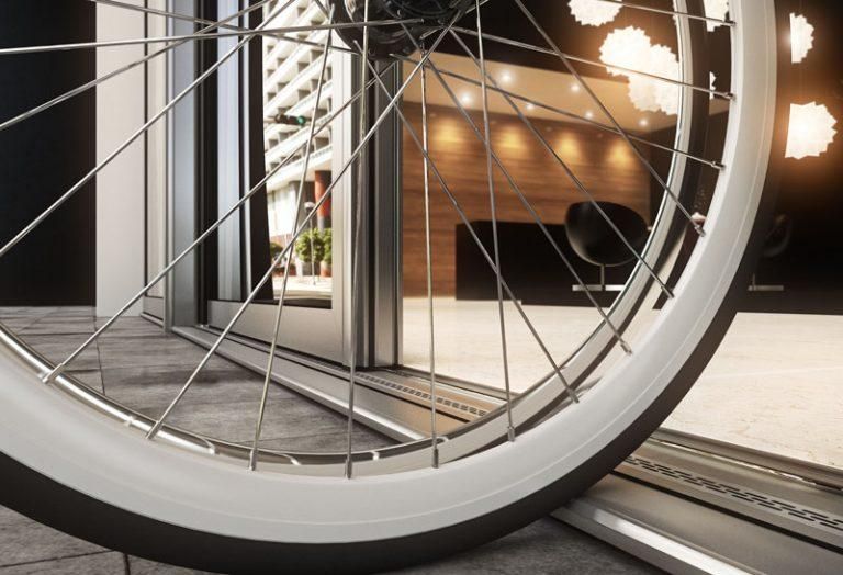 A close up of a bicycle wheel in front of a door