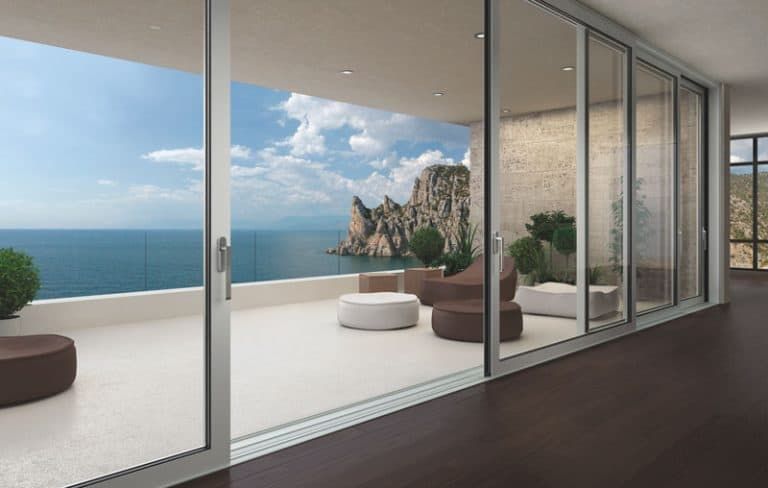 A large room with a balcony overlooking the ocean