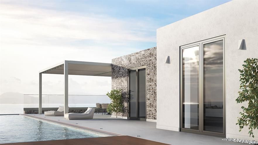 A white house with a swimming pool in front of it.