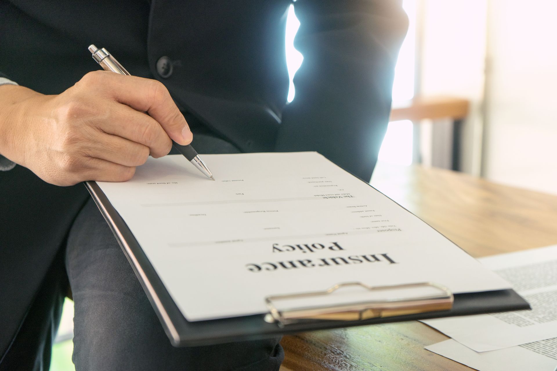 Person in suit writing on 