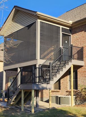 A house with a large wooden deck in the backyard.