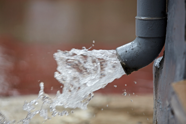 Water is coming out of a drain pipe.